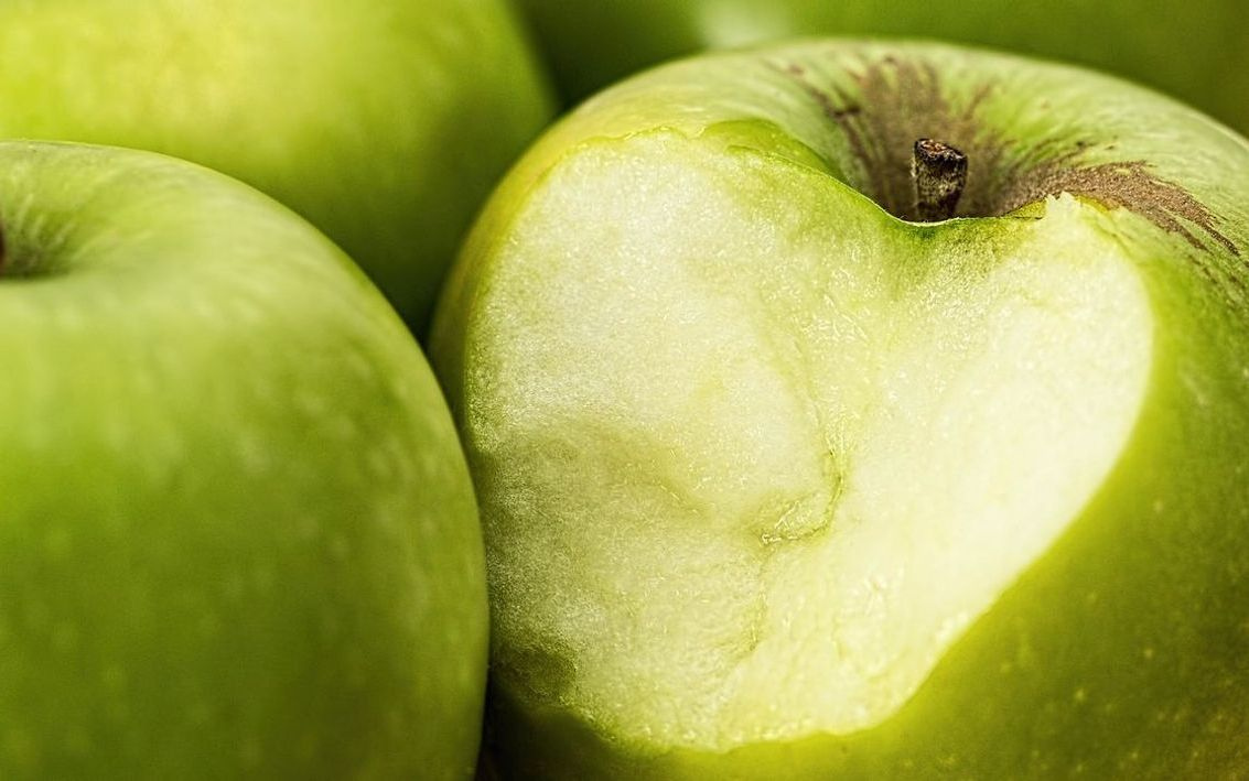 La entrada de la tienda en una esquina soleada rodeada de frutas frescas
